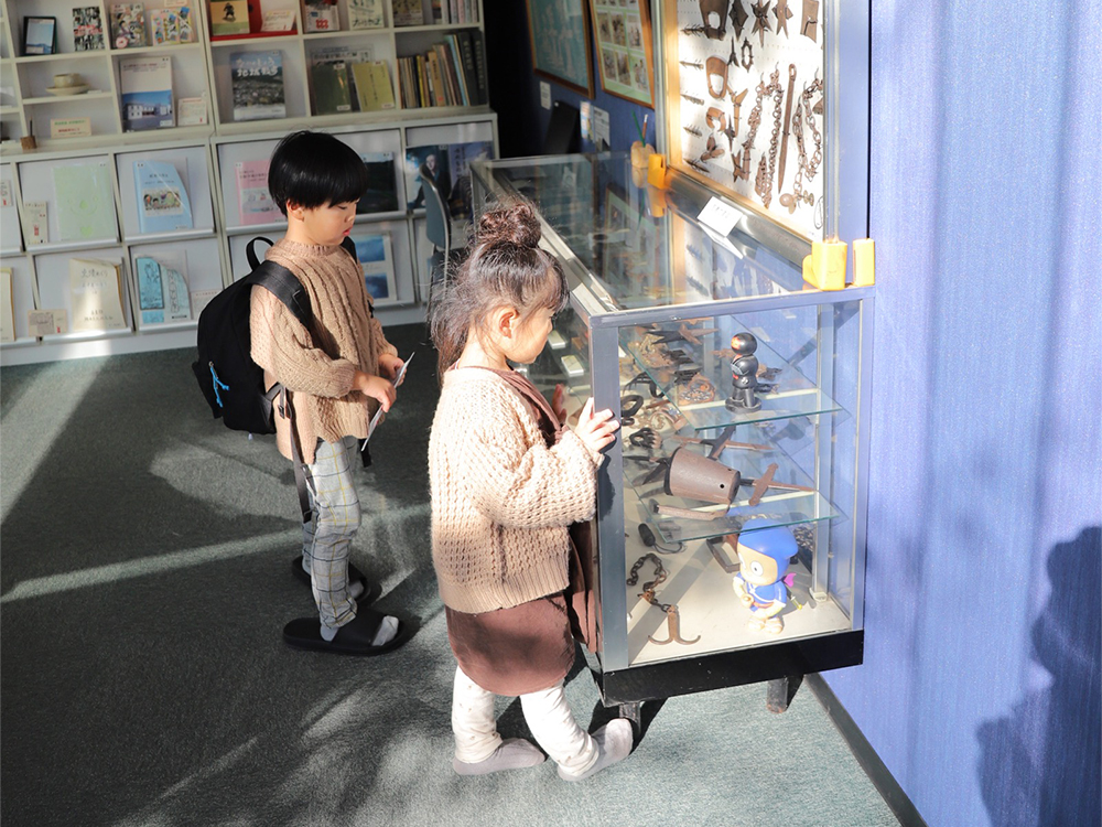 中之条町歴史と民俗の博物館ミュゼにてショーケース内の展示物を見学する子供たち