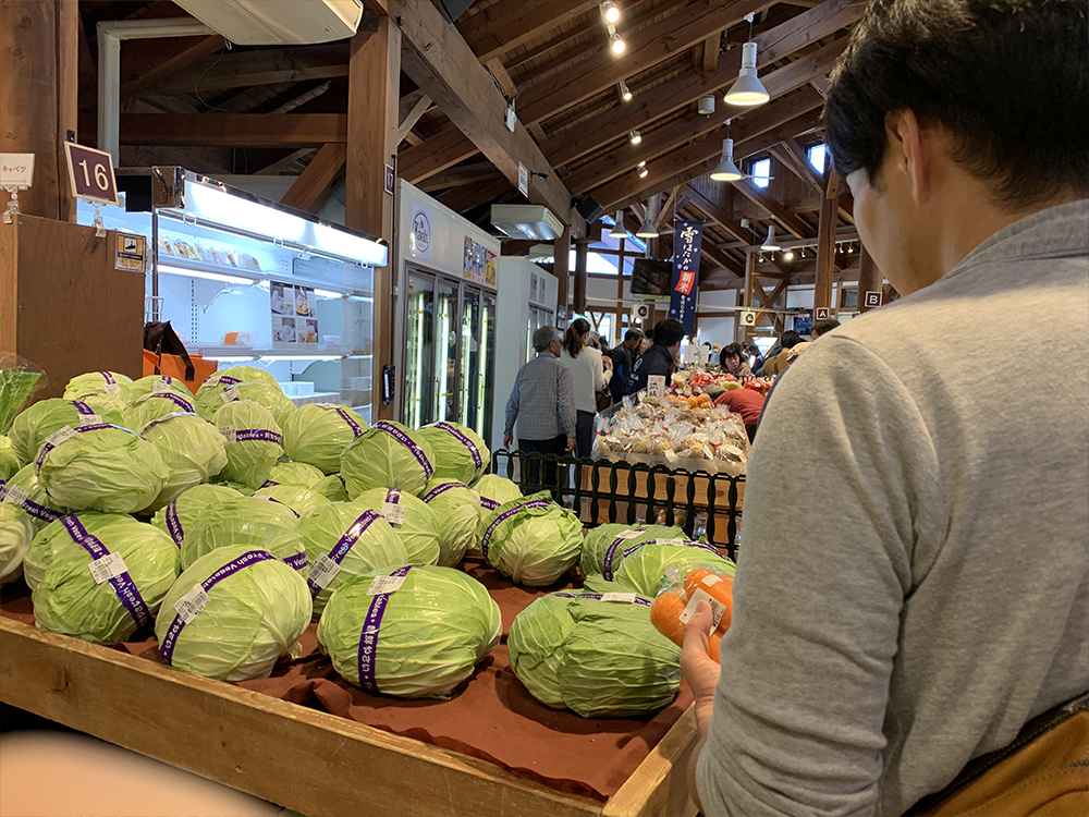 川場田園プラザの野菜販売人所で人参の購入を悩む彼氏